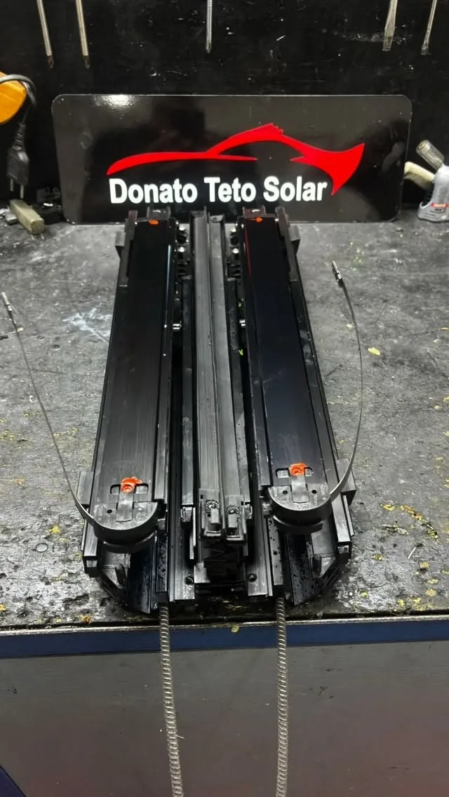 Mecanismo de teto solar desmontado na bancada da oficina